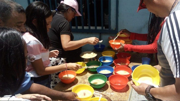 Distribuição de sopa comunitaria em Carapita, periferia de Caracas.